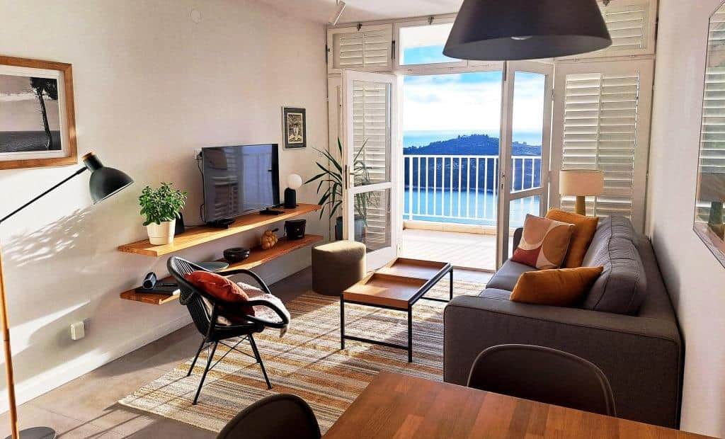 The living room opens onto a private balcony (one of two; the second balcony is off the bedrooms).