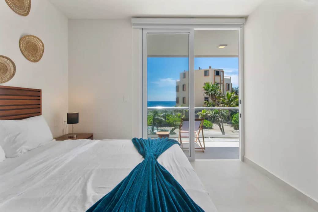 Serene bedroom with ocean views and darkening shades for restful sleep.