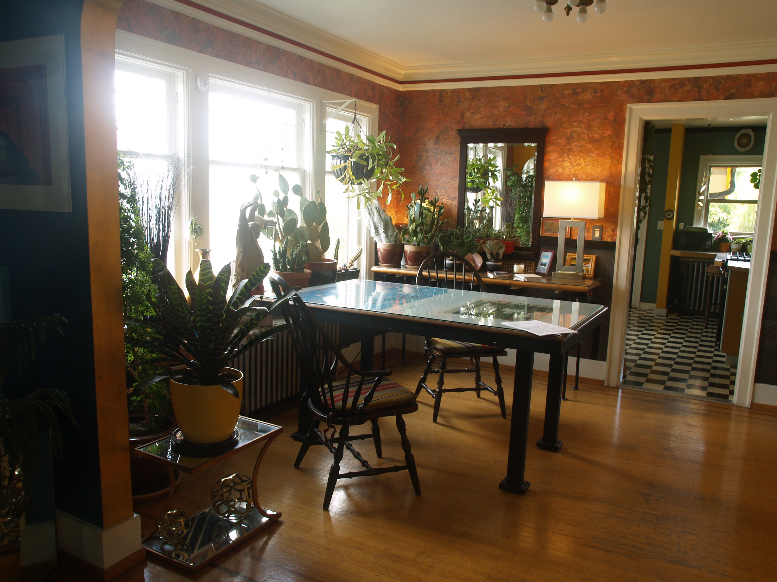 The dining room contains many cacti in the large windows and several lighting options at night.