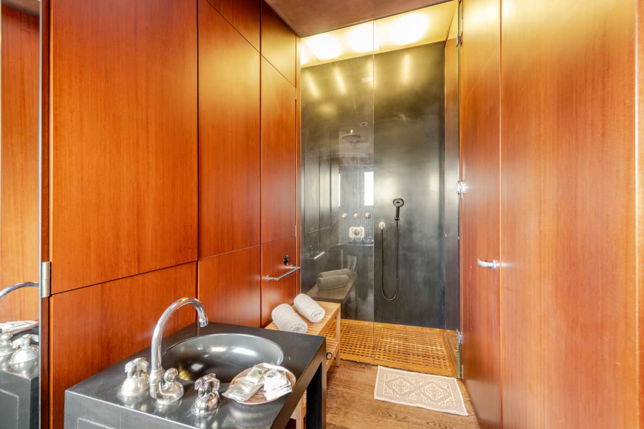Baño con lavabo de madera, espejo y toallas