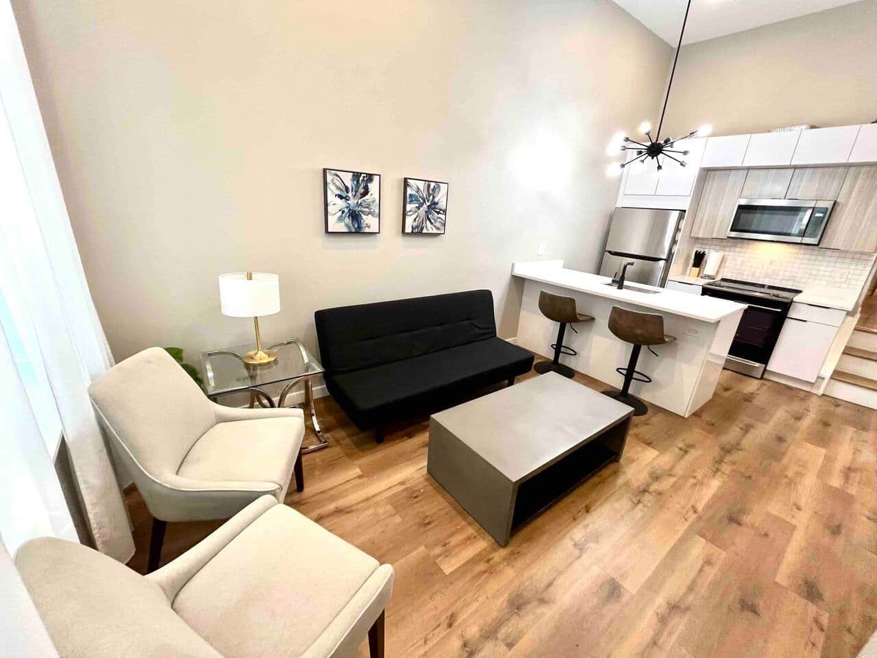 This living room boasts a flat screen tv with an impressive selection of Ruko channels. Accompanied by a comfortable futon sofa bed, two elegant living room chairs, and a generous window that graciously allows natural light to illuminate the space.