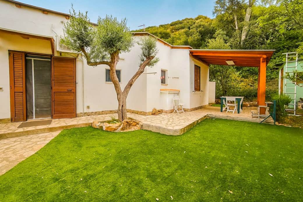 Giardino privato con patio coperto, zona pranzo esterna e olivi secolari. Un angolo di relax immerso nel verde, perfetto per godersi l'aria aperta in totale privacy.