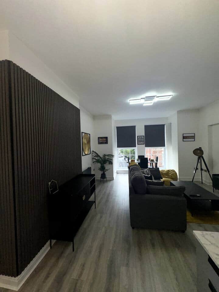 modern stylish living area with double sofa bed and smart tv, dining area