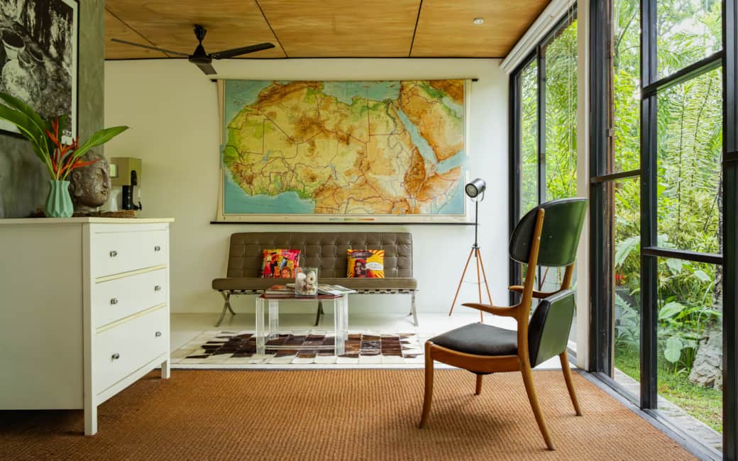 The main living area, vintage map on the wall and jungle outside every window