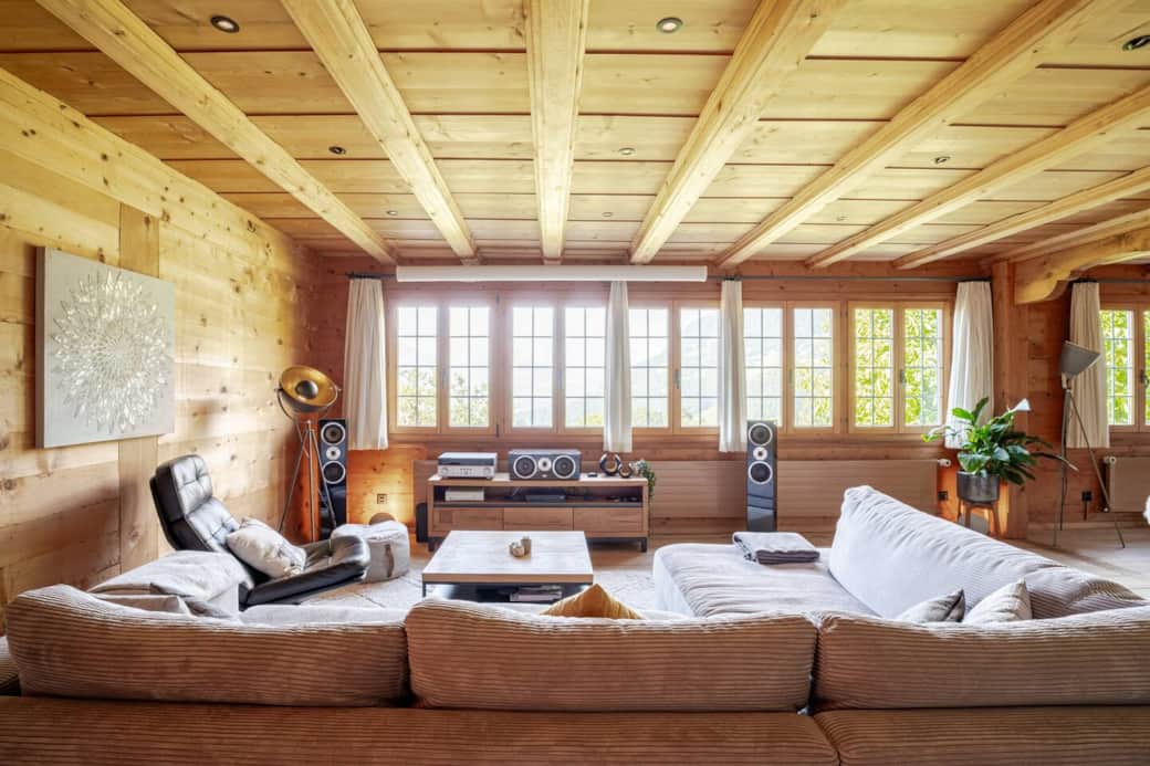 Unwind in the spacious living room, where breathtaking mountain views, a cozy tiled stove, and a state-of-the-art home theater await.