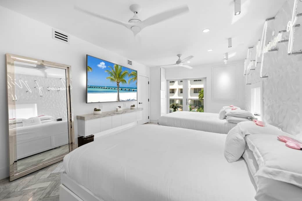 2nd FLOOR: PRIMARY BEDROOM 2 queen beds + 2 twin trundle beds (sleeps 6), 87 inch smart TV, private bedroom balcony. "Modern Mansion of Miami" wall neon on 3D wall panels. Full length mirror. 2 guest closets. Private primary bathroom attached. 2nd FLOOR: PRIMARY BEDROOM 2 queen beds + 2 twin trundle beds (sleeps 6), 87 inch smart TV, private bedroom balcony. "Modern Mansion of Miami" wall neon on 3D wall panels. Full length mirror. 2 guest closets. Private primary bathroom attached.