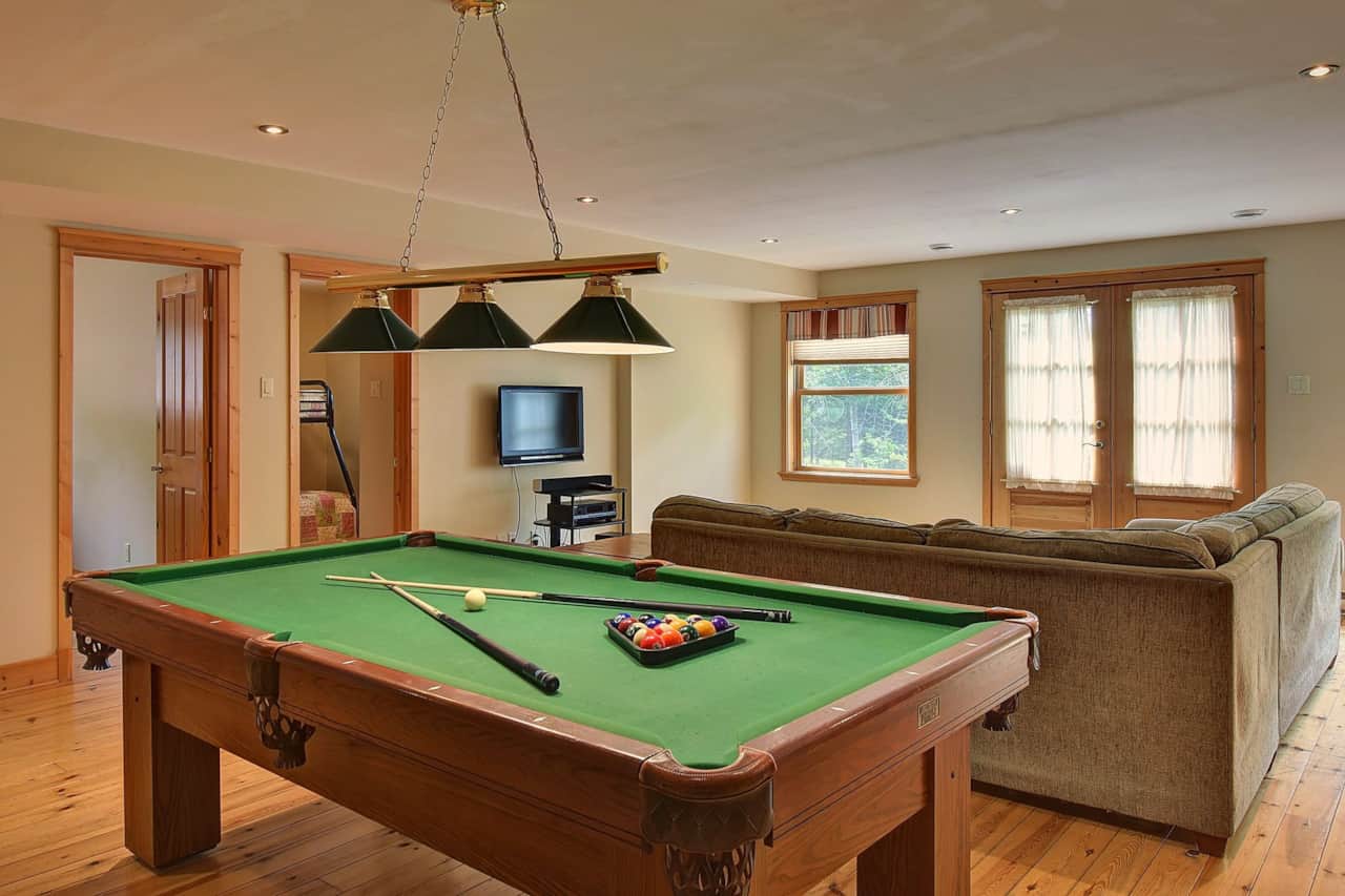 Salle de jeu avec table de billard et coin télé