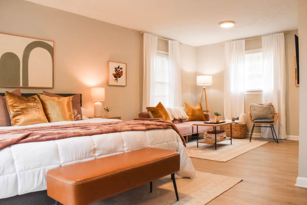 The downstairs master suite features a plush king-sized bed and cozy lounge area with twin-size sofa The downstairs master suite features a plush king-sized bed and cozy lounge area with twin-size sofa