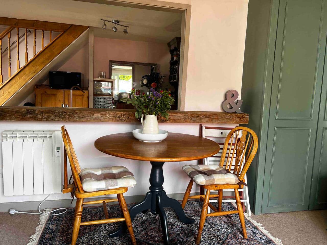 In the lounge area is a table with 2 fixed chairs and 2 x folding chairs. 