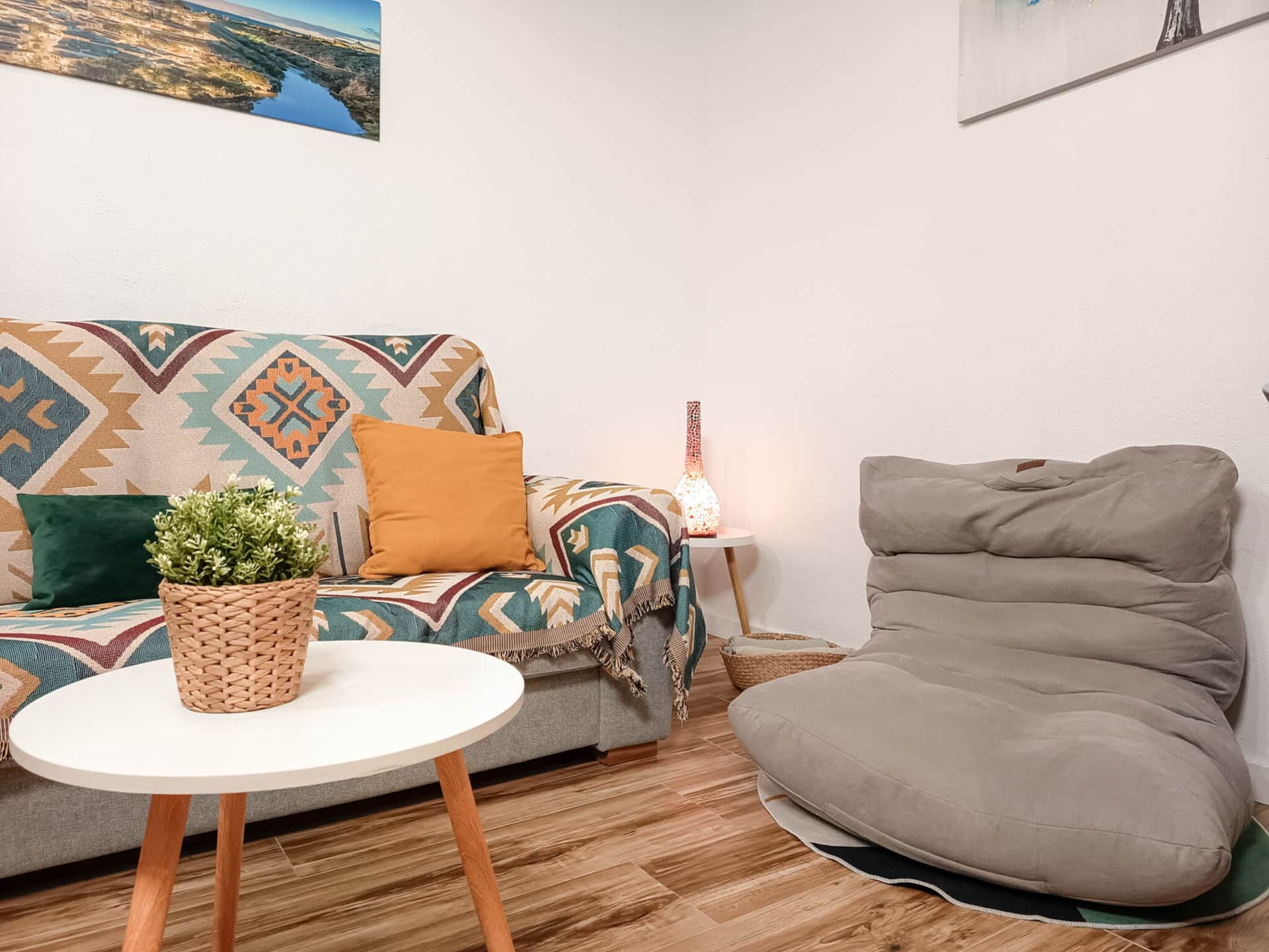 Detalle del salón con sofá, sillón y mesa auxiliar en casa rural cerca de Puy du Fou Toledo