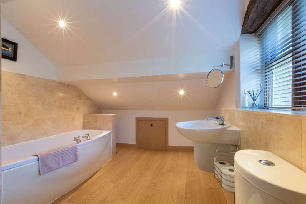 Bedroom 1's large ensuite bathroom with bath, separate shower cubicle, basin & toilet