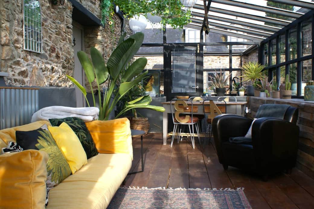 Lightfilled orangery, canary yellow sofa and table for four. Perfect for an early morning cuppa with valley views.