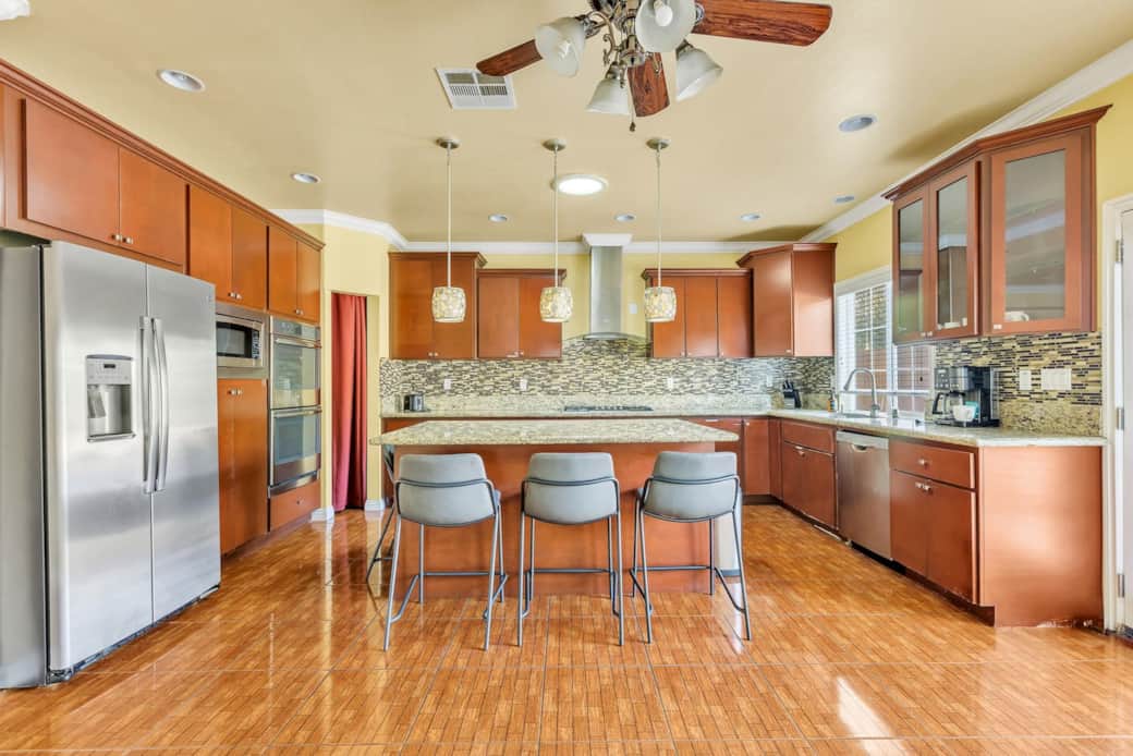 Kitchen with island seating, modern appliances, and ample counter space.