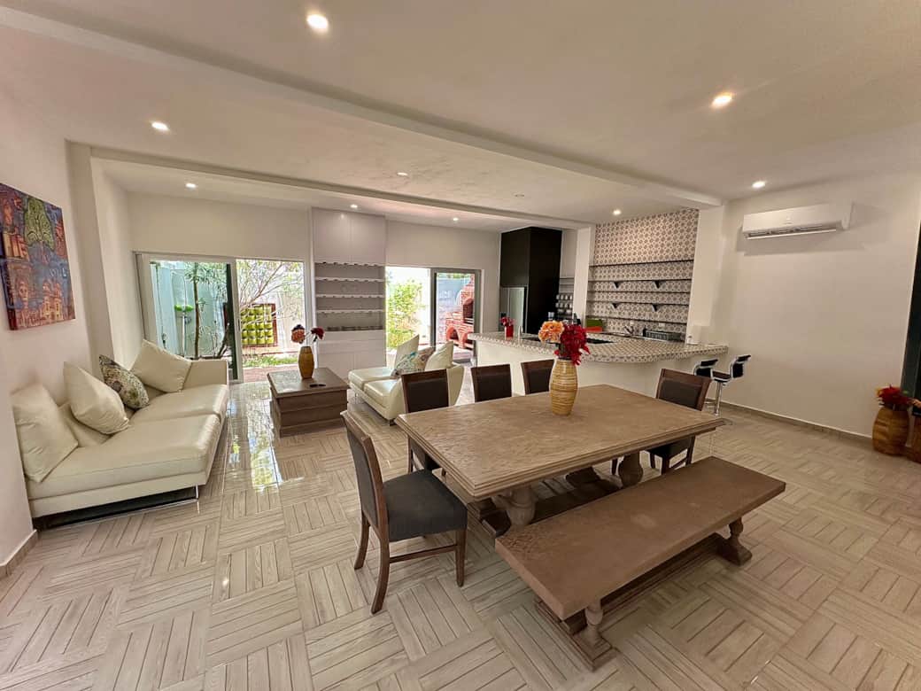 Open living space: living room, kitchen, dining area, patio with grill