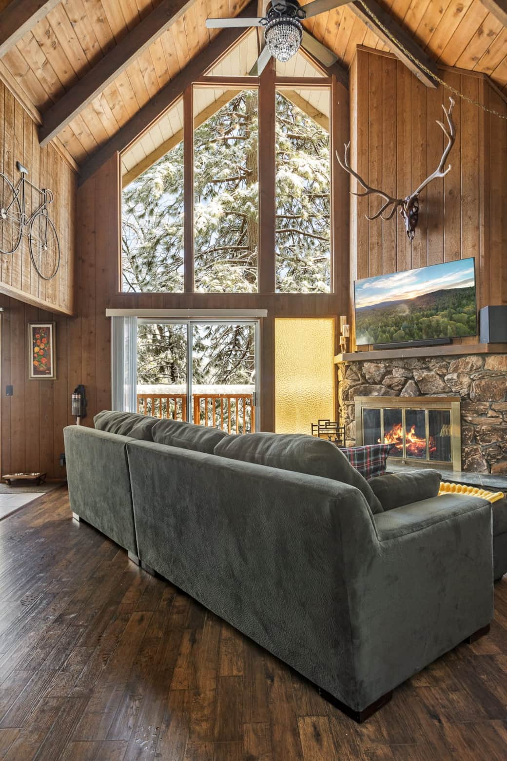 Cozy up in a spacious living room with a wood-burning fireplace, vaulted ceilings, and forest views. Cozy up in a spacious living room with a wood-burning fireplace, vaulted ceilings, and forest views.