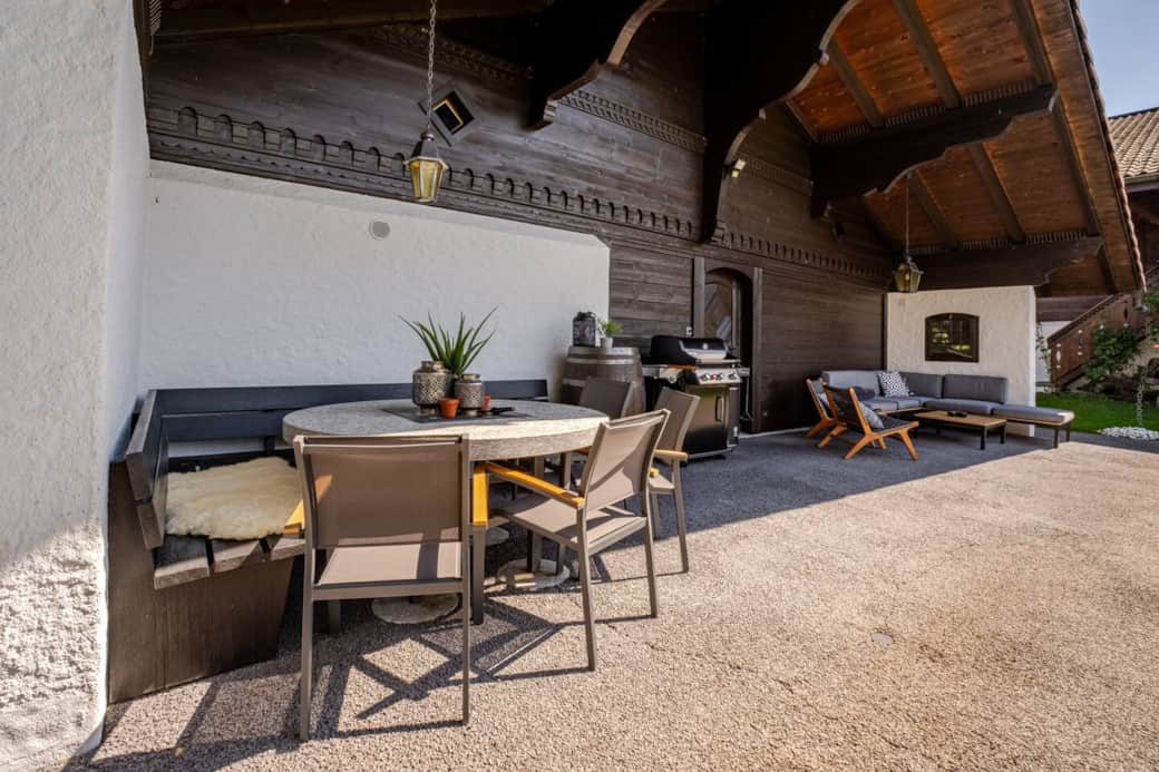 Our outdoor space features a spacious covered terrace, protected from the elements, complete with comfortable lounge seating, a granite dining table, a barbecue grill, and extra sun covers.