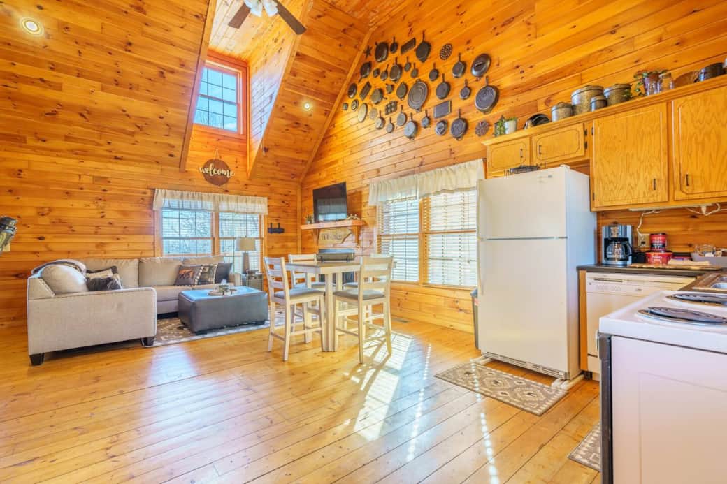 As you walk through the doors of the Cast Iron Cabin you enter into the main area. With a simple yet stocked kitchen, an high top dining table and a cozy living room with a fireplace and TV for streaming. Large windows and lots of light. 