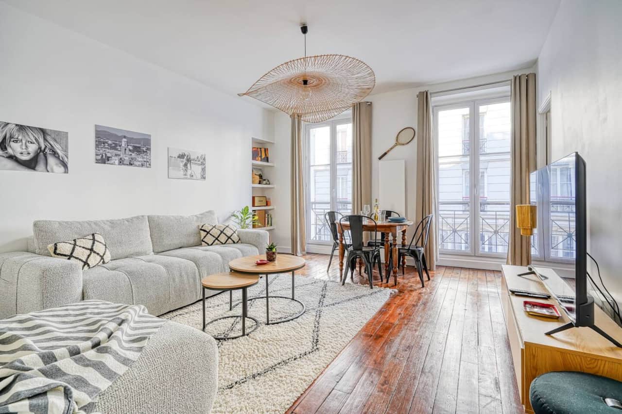 Un salon spacieux et lumineux au style bohème chic, parfait pour se détendre après une journée à explorer Paris 