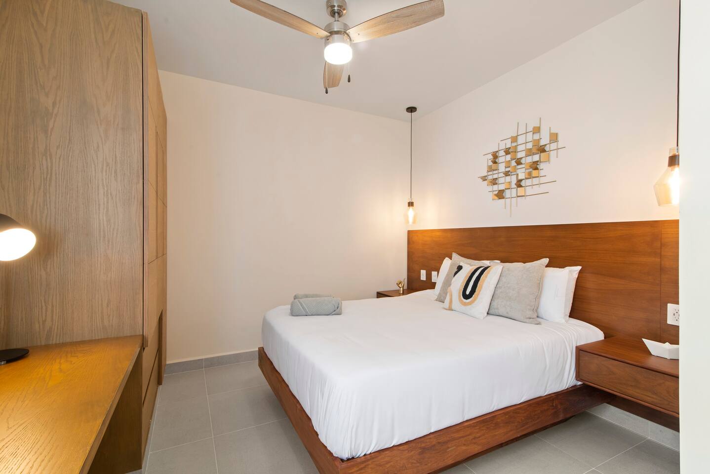This comfortable bedroom features a queen-size bed, AC, a ceiling fan, and room-darkening shades for a restful stay. It also includes a dedicated workspace for remote work, a full wardrobe, and plenty of space to unwind.