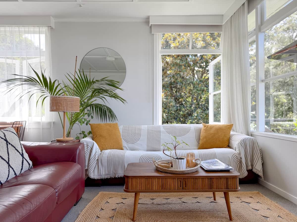 Sunny, light-filled lounge with a funky retro vibe, art and lush plants. Relax with bush and cityscape views, stunning sunrises, a 65” Smart TV with Netflix & Freeview, plus year-round comfort from the heat pump.