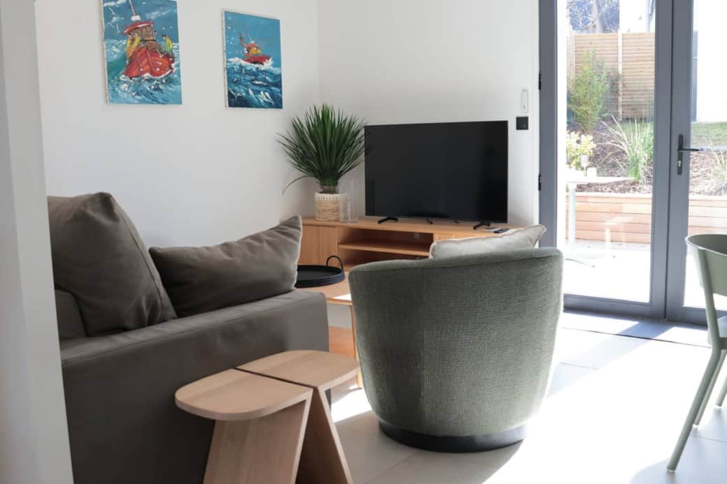 Coin salon avec grande tv et accès au jardin