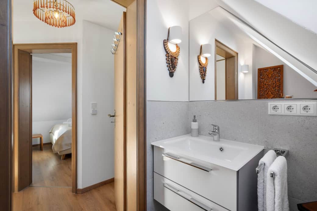 Tageslicht-Badezimmer mit Toilette und Waschbecken. Hochwertige Fliesen und Armaturen