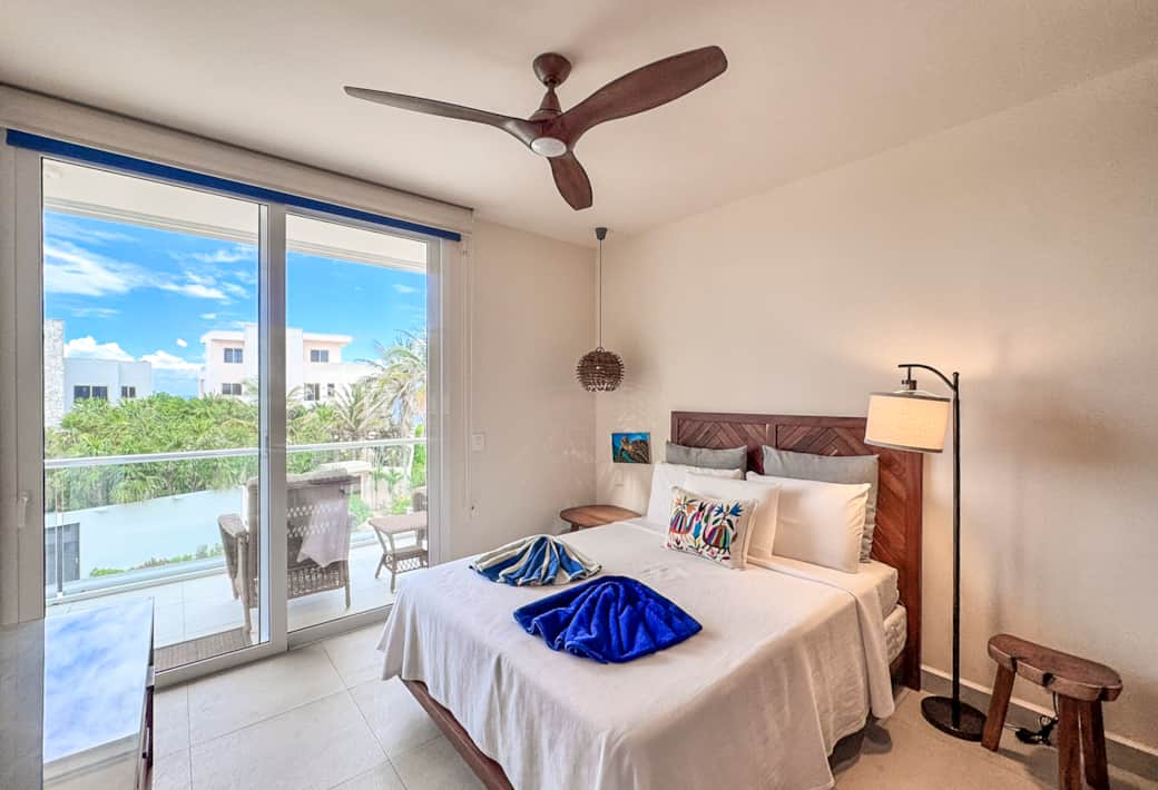 Cozy queen bed retreat with private balcony, ocean breeze, AC, and perfect sleep.