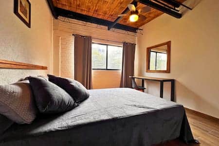 Room 9: Bright and spacious room with a cozy bed, desk, and charming wooden ceiling beams.