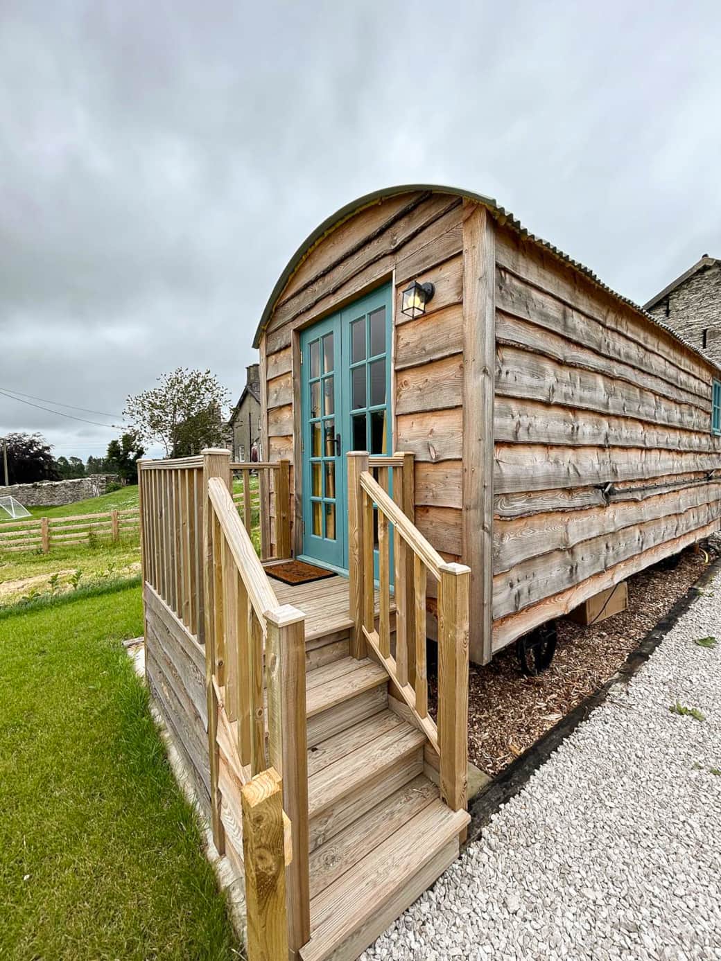 Charming timber-clad shepherd hut with private steps and countryside setting.