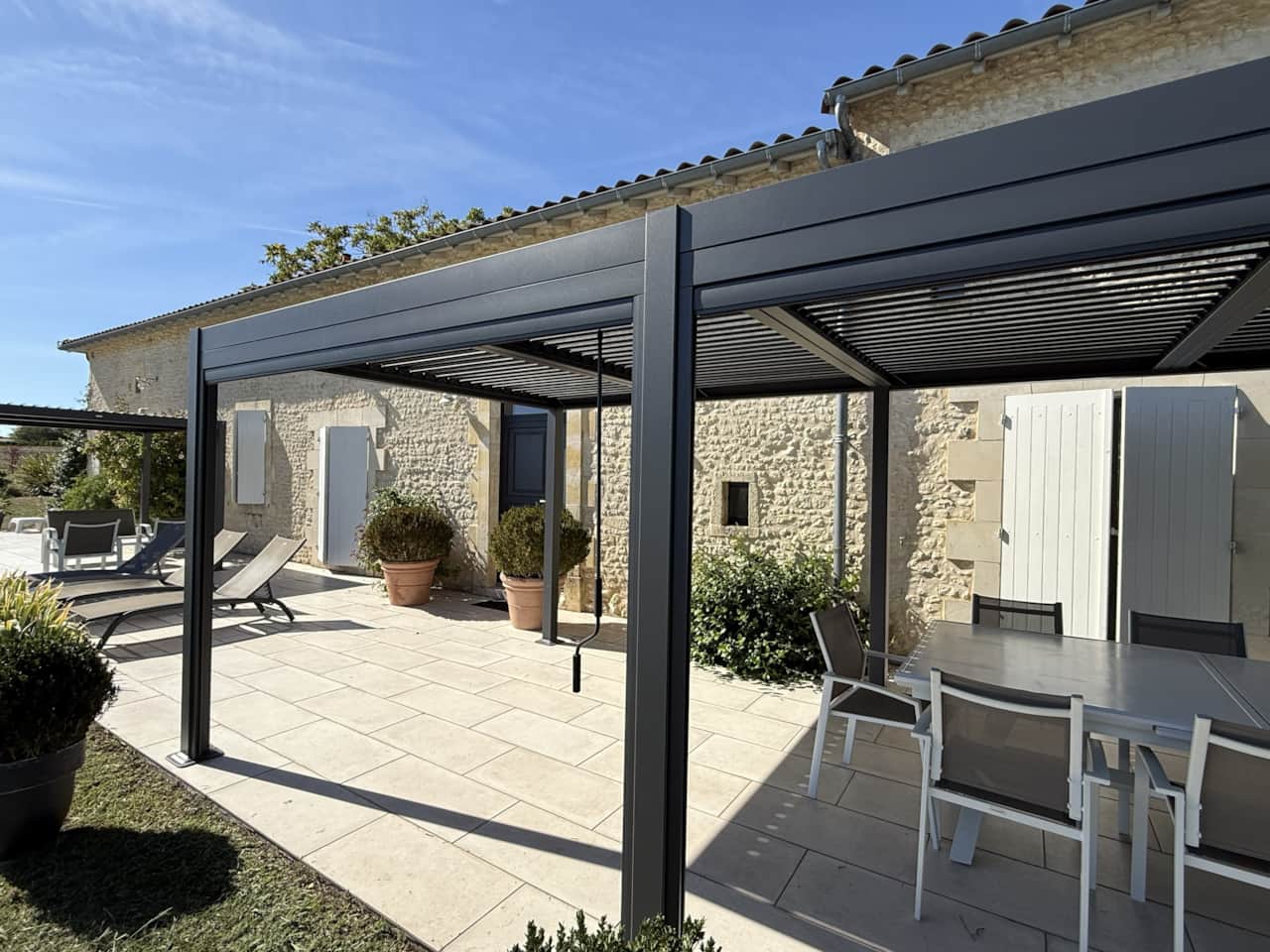 Haus und Terrasse mit bioklimatischer Pergola