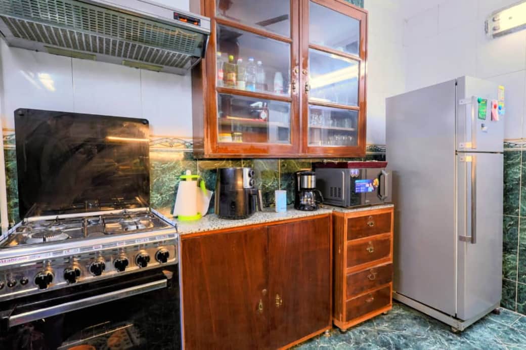 A charming kitchen features classic wooden cabinetry and modern appliancesز