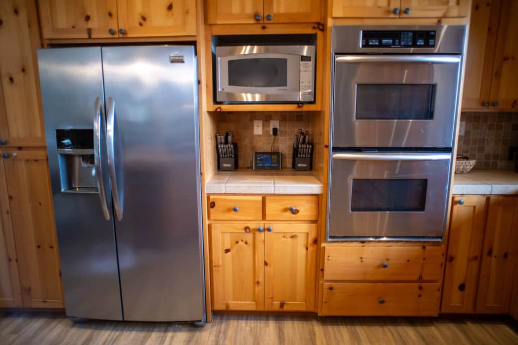 Side by side refrigerator/freezer, microwave, and double oven.