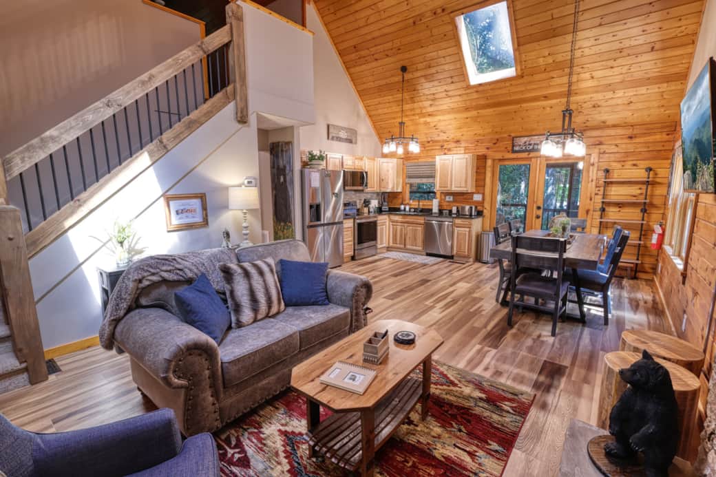 Large open living area with gas fireplace, open kitchen, vaulted ceilings, sky lights & 55" FireTV. 