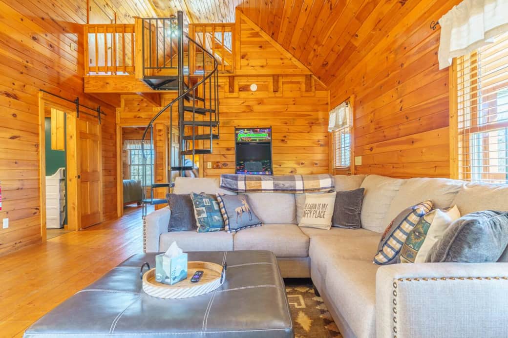 Unwind in the cozy living room of Cast Iron Cabin, where comfort meets nature. Enjoy the warmth of the fireplace, scenic views through large windows, and a TV with streaming options—ideal for movie nights or relaxing after a day of adventure