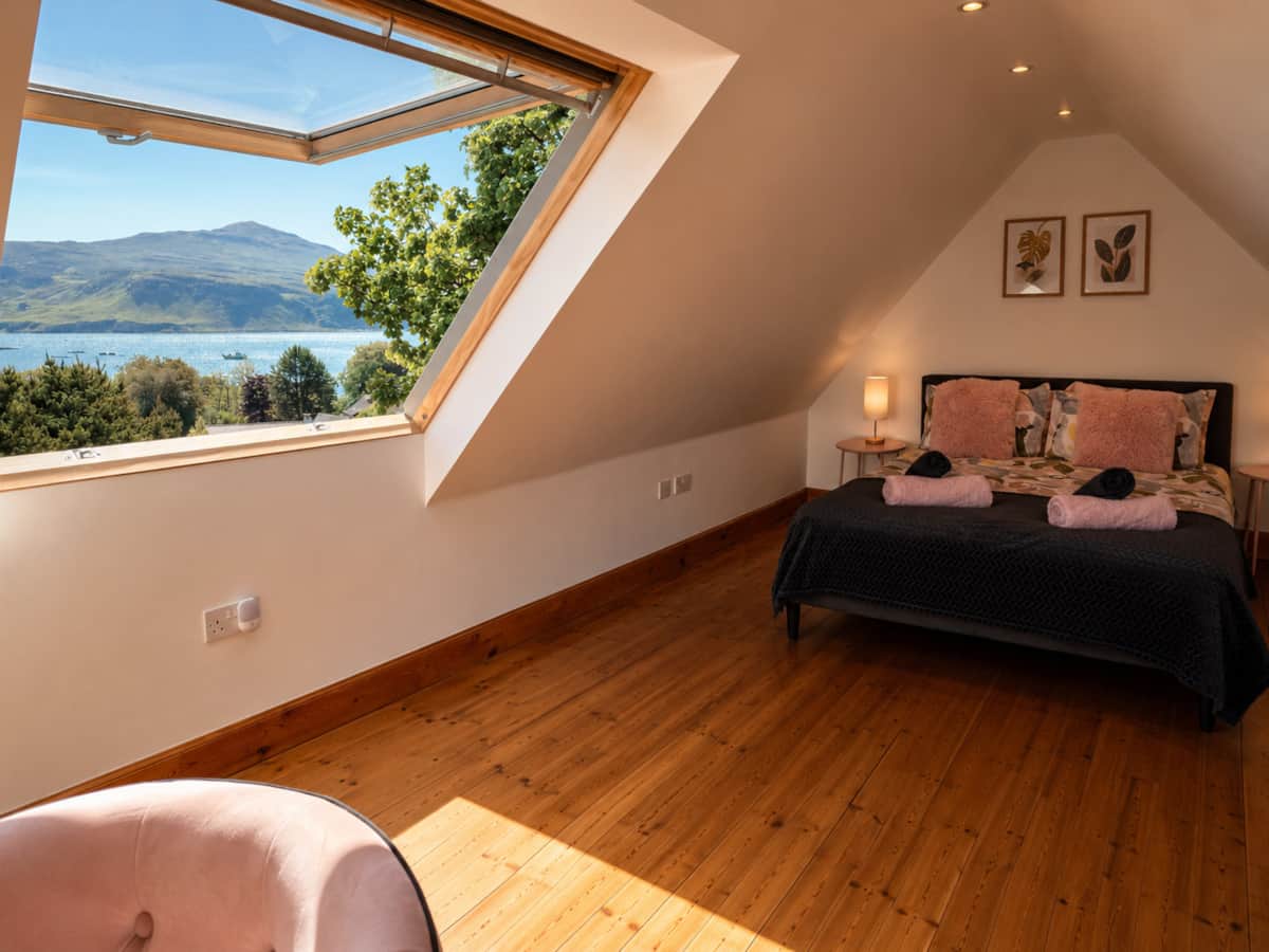 Loft bedroom skylight with views over Loch Portree, Isle of Skye.