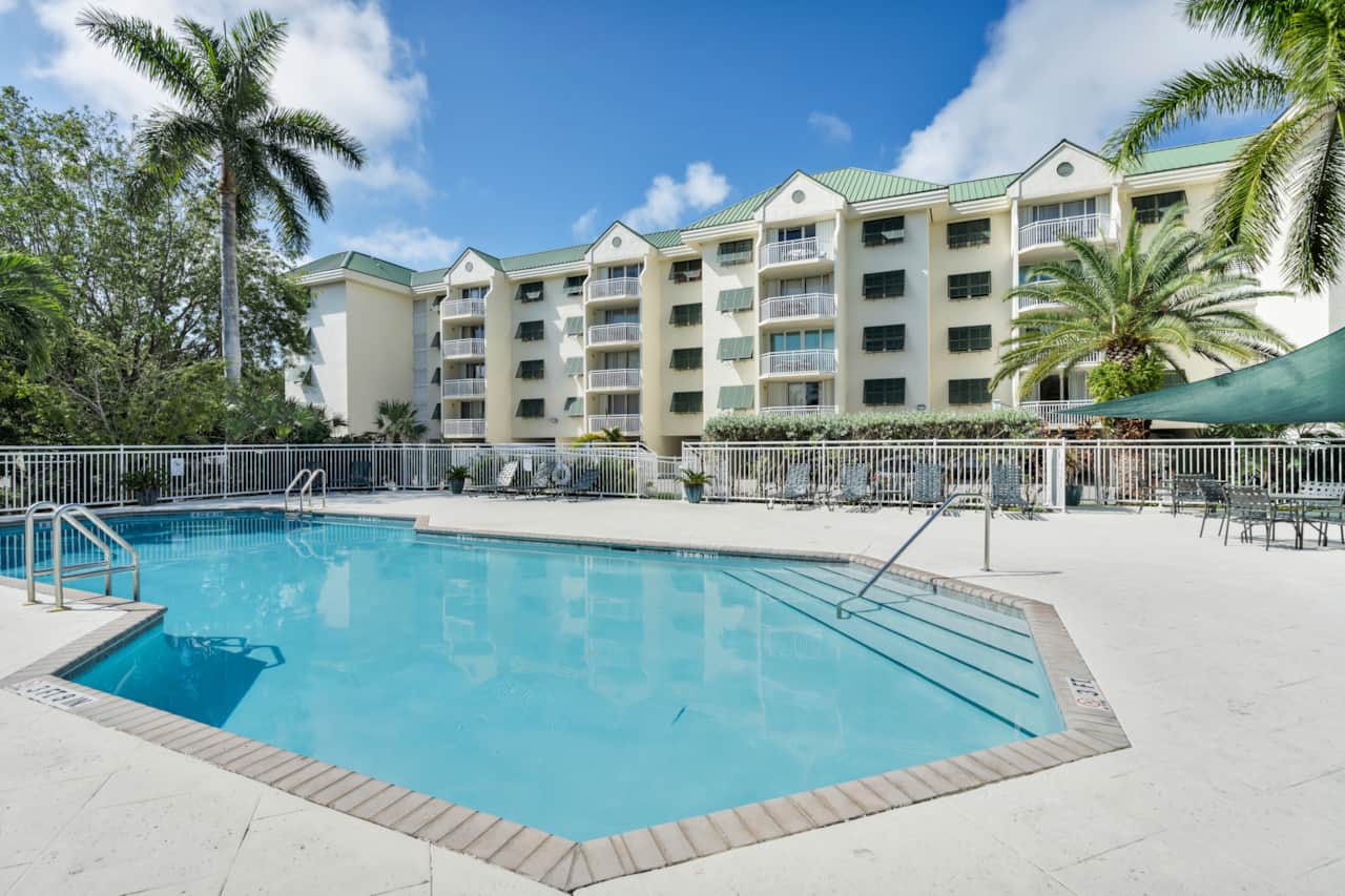Resort-style pool with loungers and sunny deck space at Sunrise Suites.