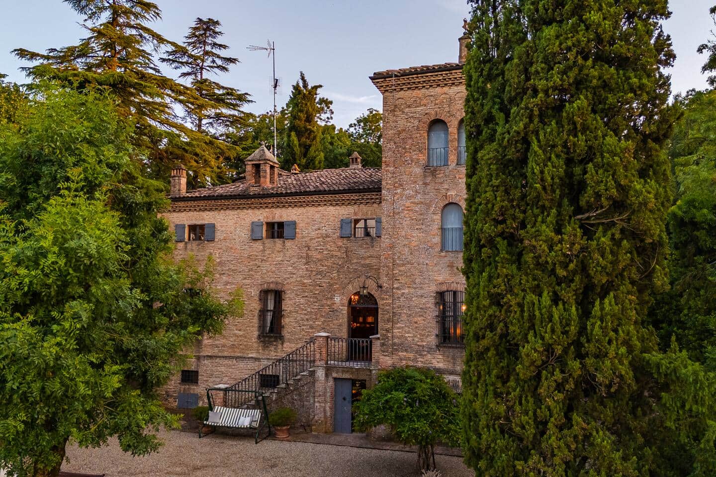 La facciata del castello tra i cipressi