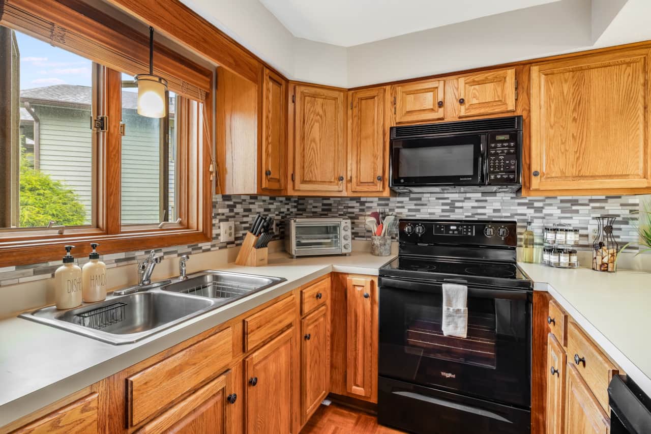 Fully equipped kitchen with black appliances, double sink, and everything you need to cook in.  