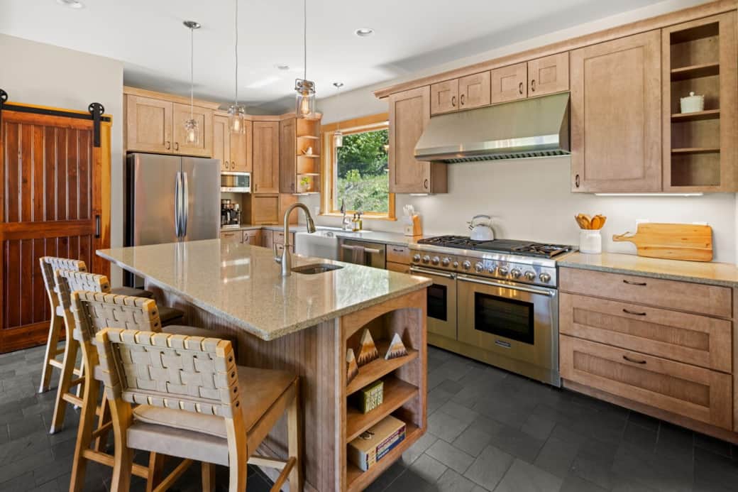 Chef’s kitchen featuring a Thermador range, farmhouse sink, quiet Bosch dishwasher, and a large island with prep sink