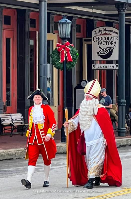 Victorian-costumed performers walking together during Dickens on the Strand festival in Galveston