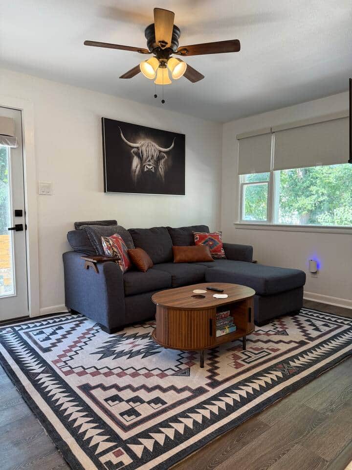 This living room is pure Southwest-cozy. Stretch out on the deep sectional, sip something warm, and admire that handsome highland cow watching over you. Between the bold rug, cozy pillows, and soft light, you may never want to leave this corner.