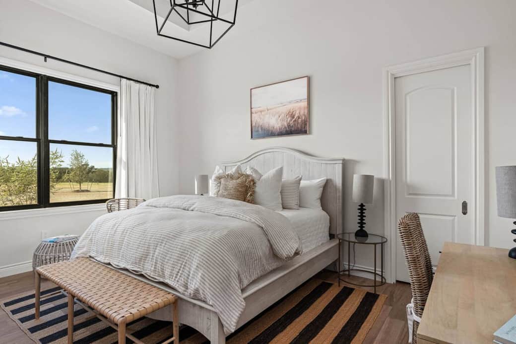 Soak in the charm of the Texas Hill Country in this luxurious bedroom with a king size bed and designated workspace. 