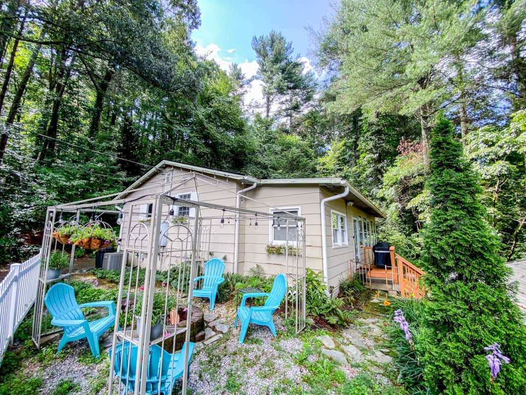 The front of the house offers a cozy fire pit and welcoming string lights.
