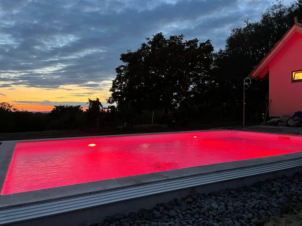Beleuchteter Pool im Abendrot