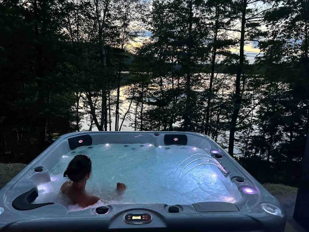 The hot tub is just outside the door on the large outdoor livingroom overlooking the lake.  