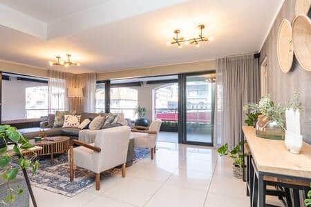A stylish and spacious living room with modern furnishings and abundant natural light. A stylish and spacious living room with modern furnishings and abundant natural light.