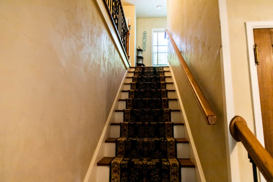 Classic carpeted staircase leads to peaceful second-floor guest rooms