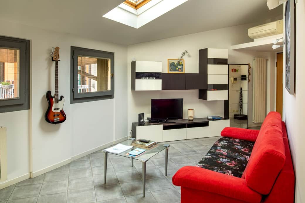 Rilassati nell'ampia zona living: un comodo divano ti aspetta per guardare la TV o navigare senza limiti grazie alla connessione Wi-Fi ad alta velocità