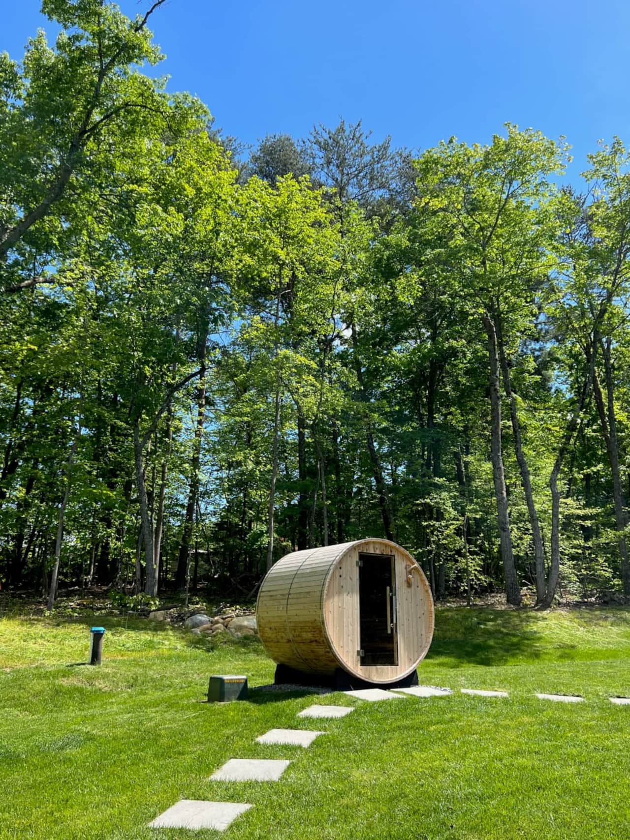 Tranquil cedar barrel sauna set at the edge of the woods- a fantastic place to relax and rejuvenate