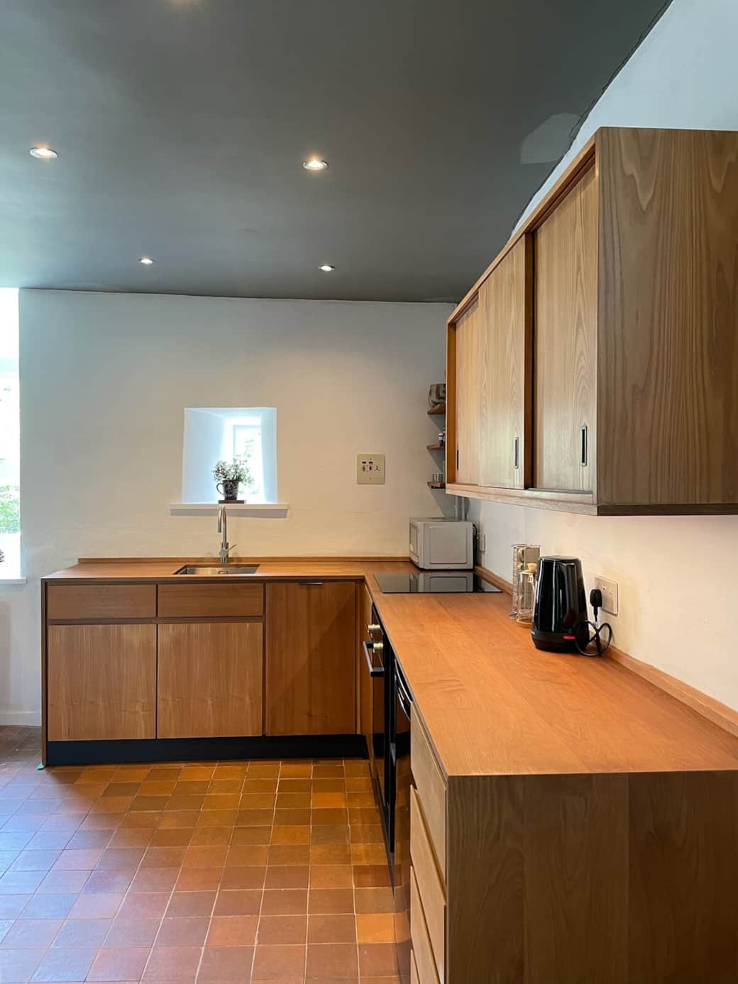 The kitchen is  well equipped with Bosch appliances and induction hob and a range of cooking utensils for preparing meals.. Warm light ceiling spot lighting and undercounter accent lighting operated by proximity sensor provide illumination 